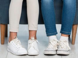 Close-up girls legs wearing white sneakers