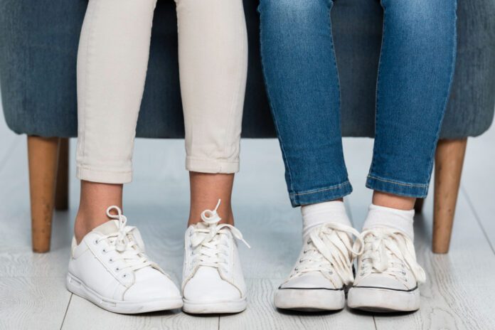 Close-up girls legs wearing white sneakers