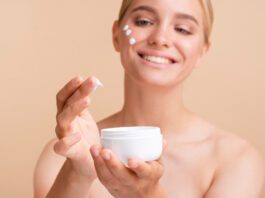 woman holding face cream container