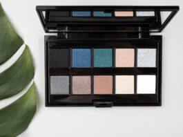 Blue‑eyed woman applying the best eyeshadows for blue eyes from a flattering color palette