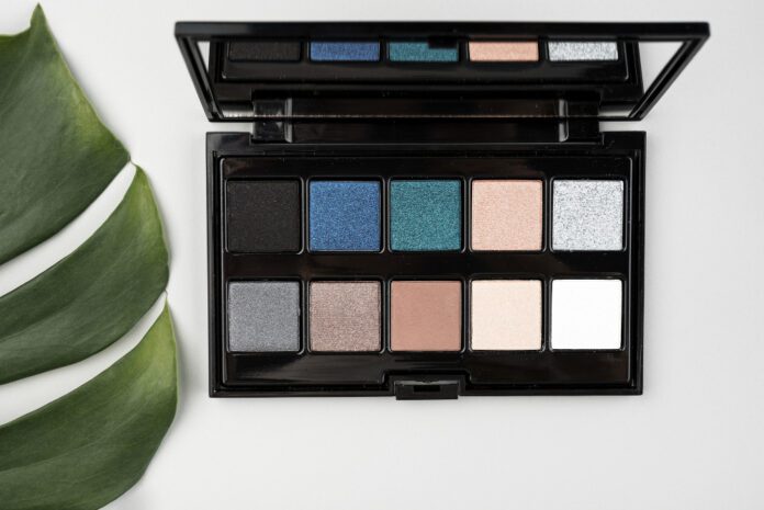 Blue‑eyed woman applying the best eyeshadows for blue eyes from a flattering color palette