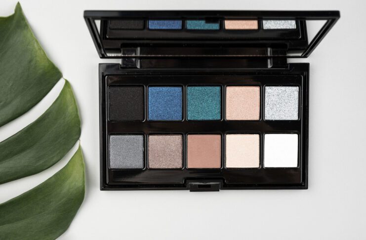 Blue‑eyed woman applying the best eyeshadows for blue eyes from a flattering color palette